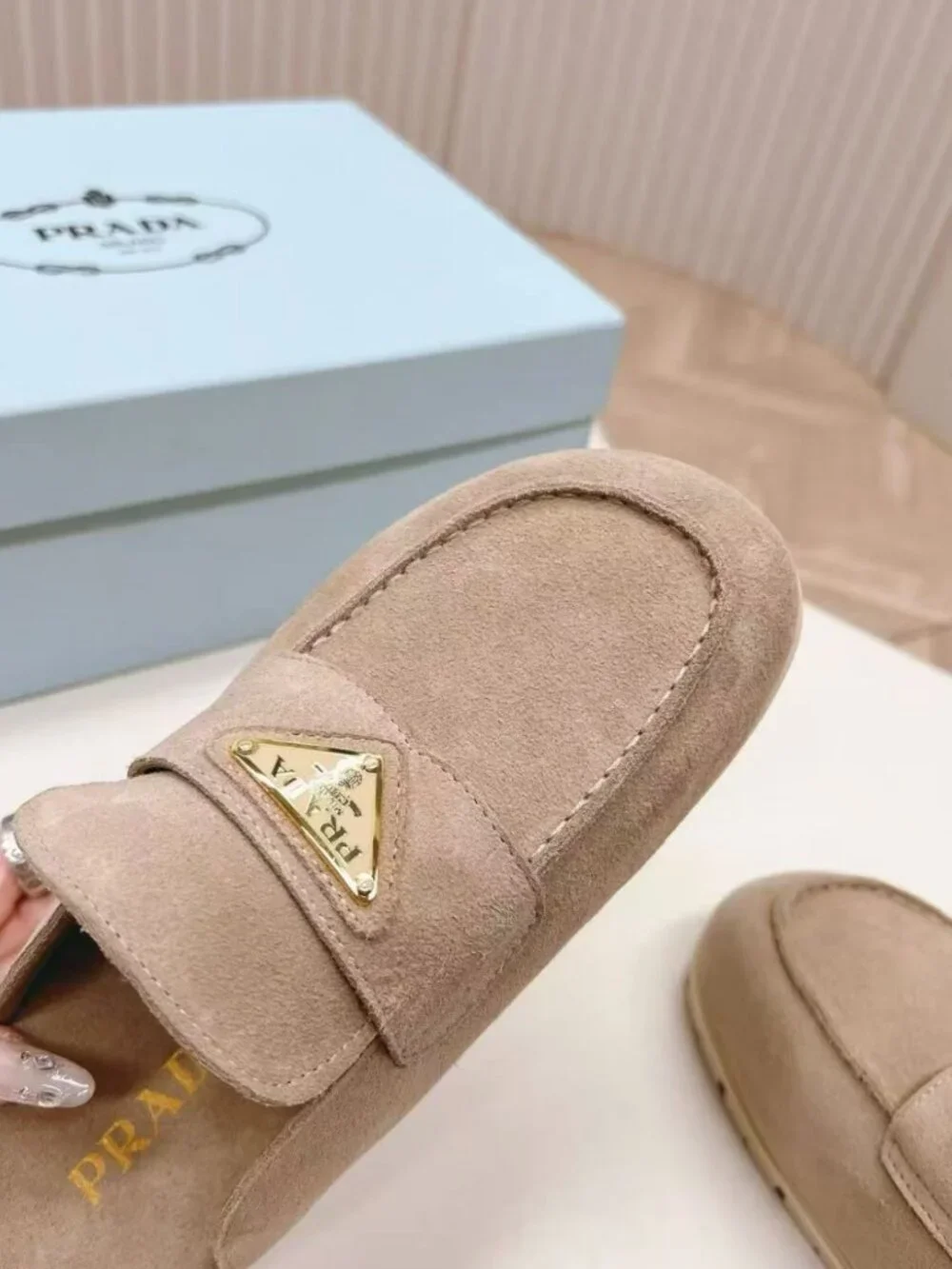 Prada beige slip‑on mules with triangular logo badge